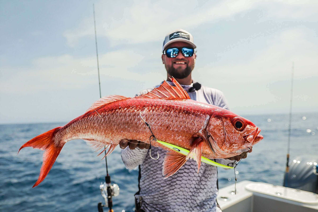 Angler proudly displaying a queen snapper caught while slow pitch jigging with JYG Pro Fishing.