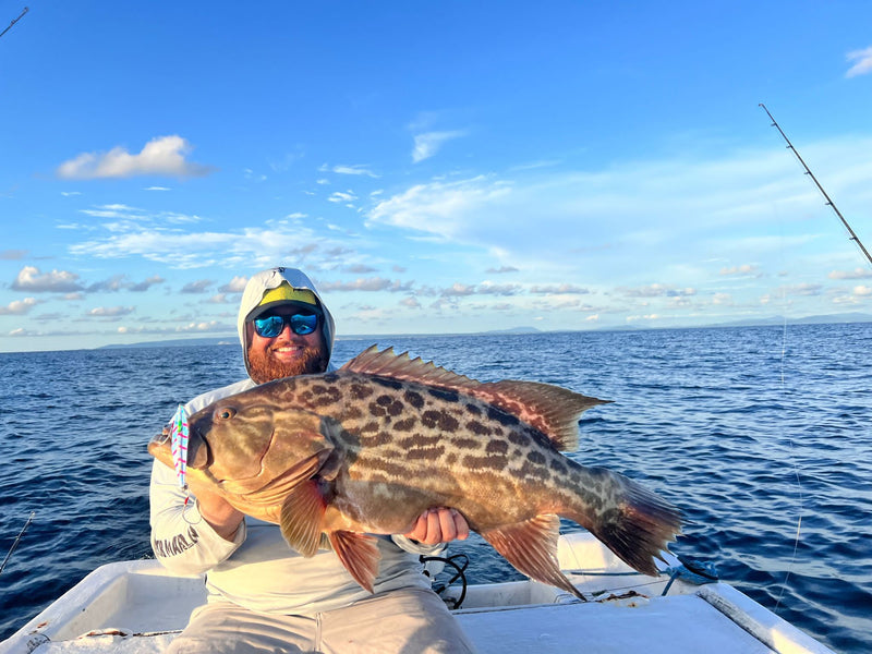 Angler holding a broomtail grouper on a boat off Puerto López, Ecuador