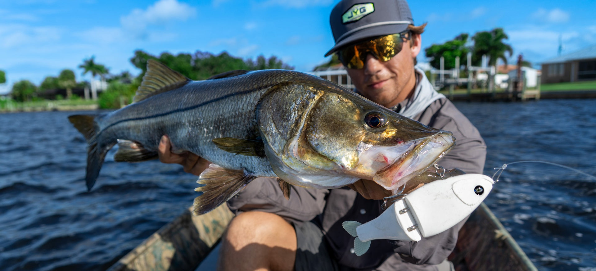 Angler holding a snook caught on a white GLYDE glide bait