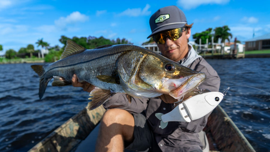 Angler holding a snook caught on a white GLYDE glide bait