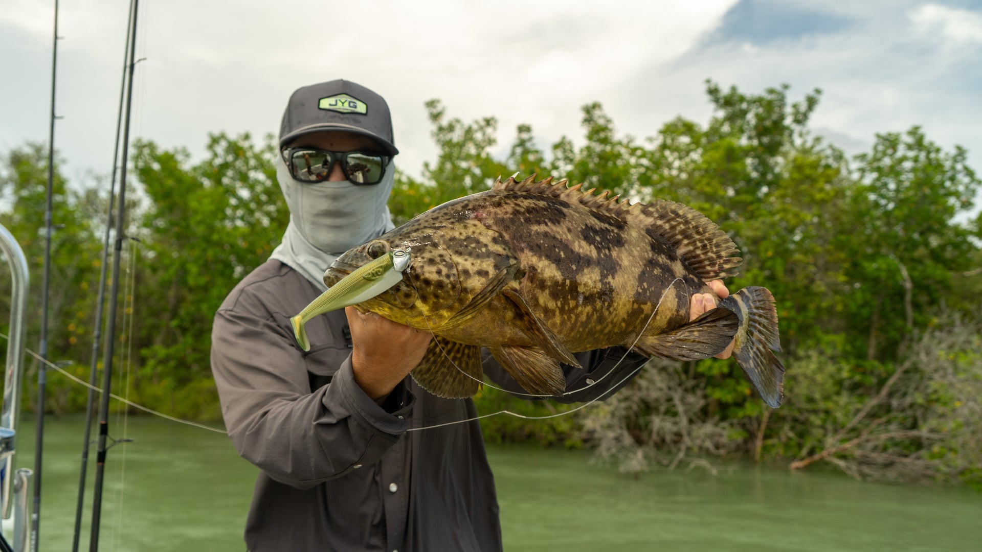 Angler holding a grouper caught on a JYG CHUBBY 5 inch paddle tail in the mangroves